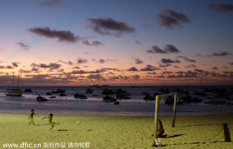 Des enfants jouent au football avec leur père sur la place de Mucuripe à Fortaleza, au Brésil, le 16 juin 2013. [Photo/IC]