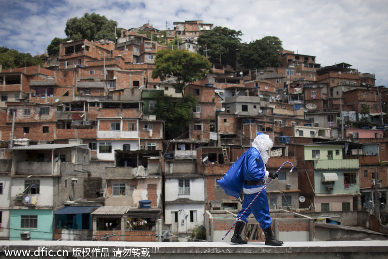 Un policier habillé en père No?l, mais en couleur bleue représentant la police, se promène dans le bidonville de Macacos, arrivé dans un hélicoptère de la police à Rio de Janeiro, au Brésil, le 20 décembre 2012. Le groupe d’intervention a organisé pour le père No?l une visite dans le bidonville pacifié afin de distribuer des cadeaux aux jeunes résidents. [Photo/IC]