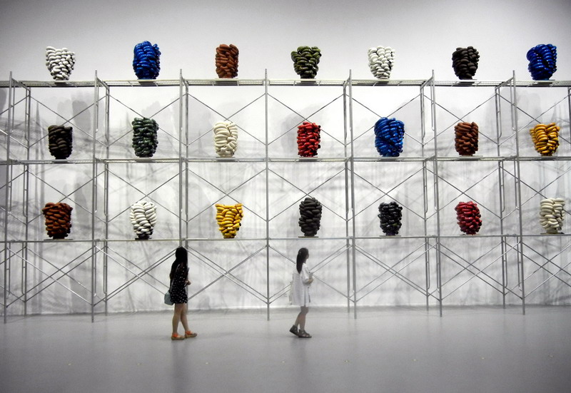 Des visiteuses admirent une ?uvre d'art en céramique de l'artiste norvégien Torbj?rn Kvasb? intitulée ? Tuyau d’évasion ?, au Musée d’Art du Lac Jinji de Suzhou, le 24 mai 2014. [Photo Wang Jiankang / asianewsphoto.com]
