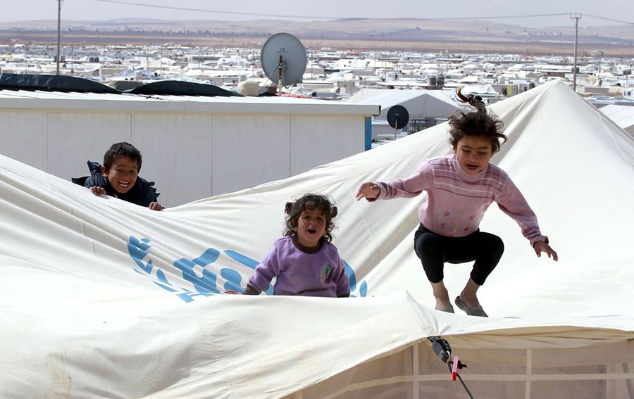 Sur cette image prise le 15 mars 2014,on aper?oit trois enfants jouant dans un camp de réfugiés dans le désert Zaatari, au nord de la Jordanie près de la frontière avec la Syrie. Site offrant un abri pour environ 100 000 réfugiés syriens. Une guerre brutale a éclaté en Syrie entre le régime d'Assad et ses ennemis et depuis n’a pas faibli, en tuant au moins 146 000 personnes depuis mars 2011. Plus de 2,5 millions de Syriens ont fui à l'étranger et un autre 6,5 millions ont été déplacées à l'intérieur du pays. La Jordanie abritant plus de 500 000 réfugiés. 