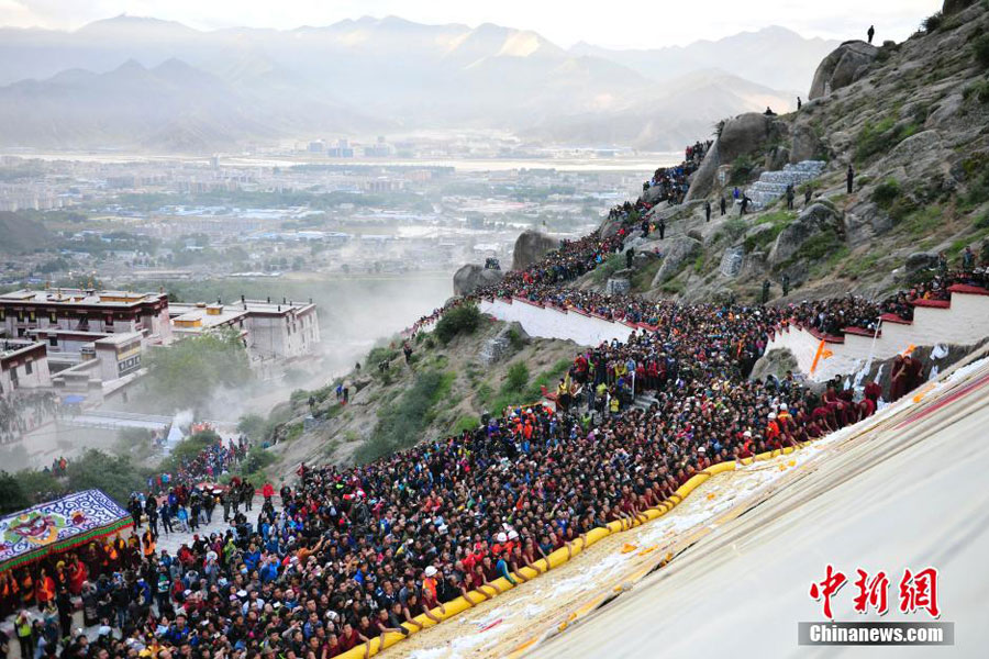 Une grande foule de moines et de touristes admirent un tangka géant du Bouddha sur une colline près du monastère de Drepung, à la périphérie de Lhassa. [Photo/Chinanews.com]