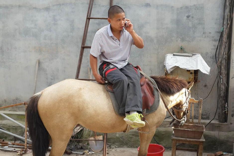 Shi Lin téléphone sur sa monture après avoir quitté le travail.