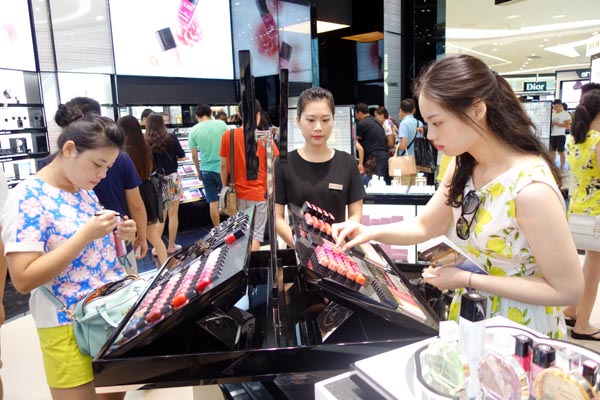  Des touristes choisissent des cosmétiques au Sanya Bay International Shopping Mall, qui a démarré ses activités lundi dans la Province insulaire de Hainan. Selon Wang Weimin, Président du China International Travel Service Group Corp, l'investisseur du centre commercial, ce lieu de 72 000 mètres carrés qui abrite 300 marques internationales est le plus grand magasin hors taxes du monde.