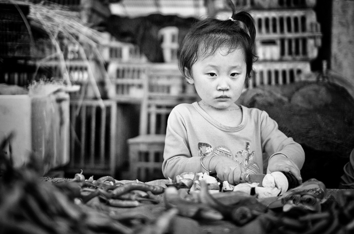 Une fillette aide sa mère à préparer le d?ner.