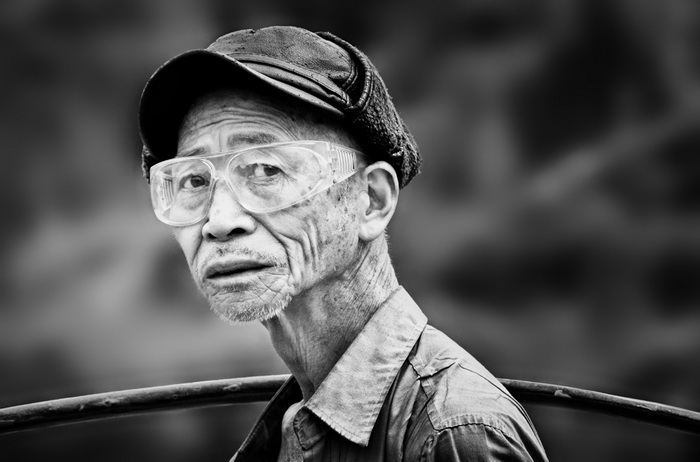 Un fermier portant une palanche dans le village de Xinping.