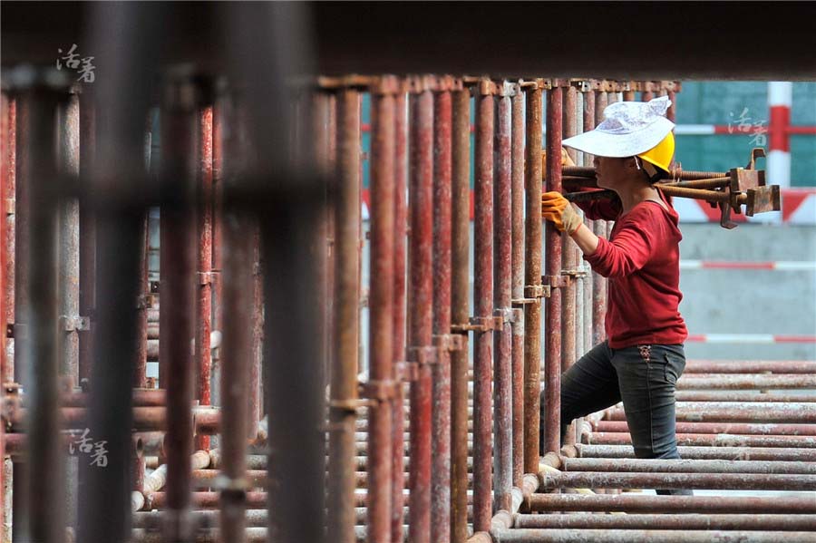 Yang Yashan, 30 ans, se fraye un chemin à travers un labyrinthe de tuyaux en acier. Peu de femmes évoluent dans ce domaine car cela est très dangereux. Yang, qui construit des immeubles comme son mari, est venue travailler à la ville pendant un an. [Photo/qq.com]