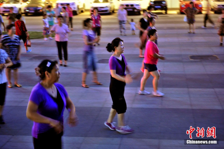 Des femmes d’age m?r dansent sur un espace libre du centre commercial Grand Canyon, au bord du troisième Périphérique Sud. Photo Jin Shuo pour Xinhua. 