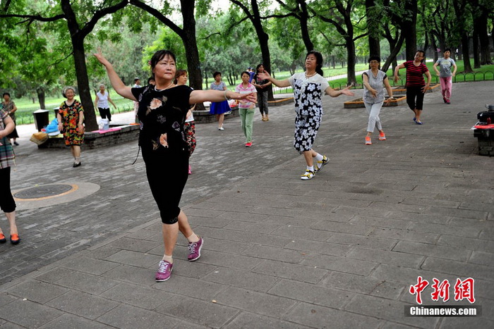 La danse de square ? Centre de l'univers ? devant le centre commercial Joy City de Shuangjing. Ici se réunissent tous les soirs à 19h trois générations de danseurs qui arrivent petit à petit, formant toutes sortes de petits groupes séparés de danse de square, qui ont t?t fait de remplir cet endroit. Photo Jin Shuo pour Xinhua. 