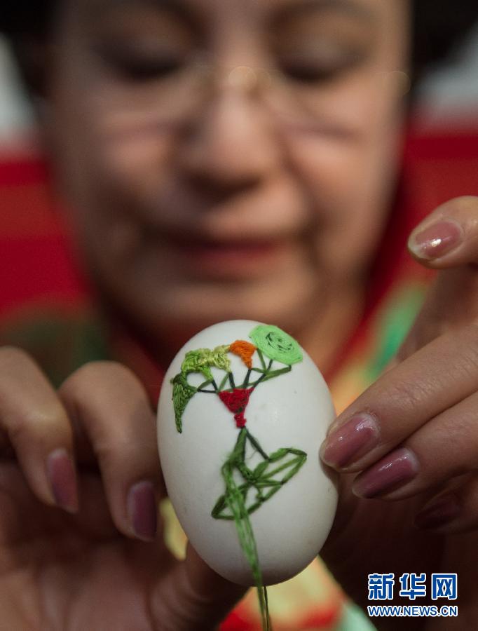 Une artiste présente son oeuvre ? oeuf peint ? à l’exposition, le 7 novembre.