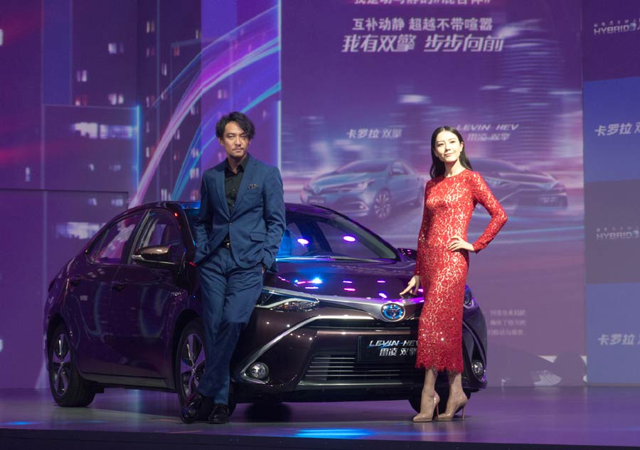 Pose de luxe, pour les acteurs chinois Zhang Zhen et Gao Yuanyuan, aux c?tés de la Toyota Levin Twin Engine hybrid, à l'occasion du 16e Salon international de l'automobile de Shanghai, le 20 avril 2015. [Photo/IC].