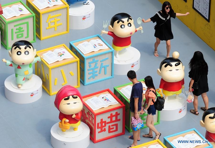Des gens visitent une exposition pour célébrer le 25ème anniversaire de Crayon Shin-chan, une série japonaise de manga et d'anime créée par Yoshito Usui en 1990, à Shenyang, capitale de la province du Liaoning, le 11 juillet 2015. (Xinhua)