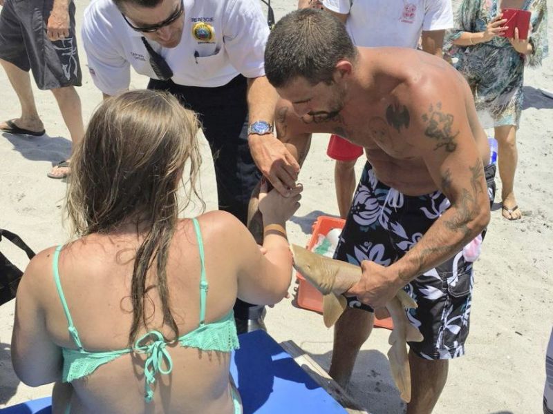 Une jeune Américaine sort de la mer avec un requin accroché à son bras