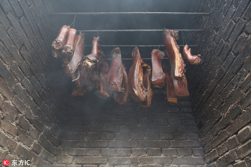 Les habitants du Sichuan portent des lunettes pour fumer de la viande pour le Nouvel An