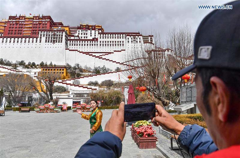 Un guide touristique parle lors d'une visite en direct du Palais du Potala, inscrit au patrimoine mondial de l'UNESCO, à Lhassa, capitale de la région autonome du Tibet (sud-ouest de la Chine), le 1er mars 2020.