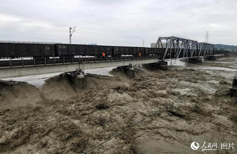 Un train de marchandises roule sur un pont pour éviter son effondrement lors des inondations
