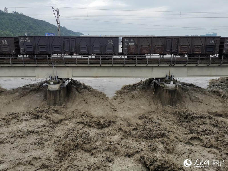 Un train de marchandises roule sur un pont pour éviter son effondrement lors des inondations
