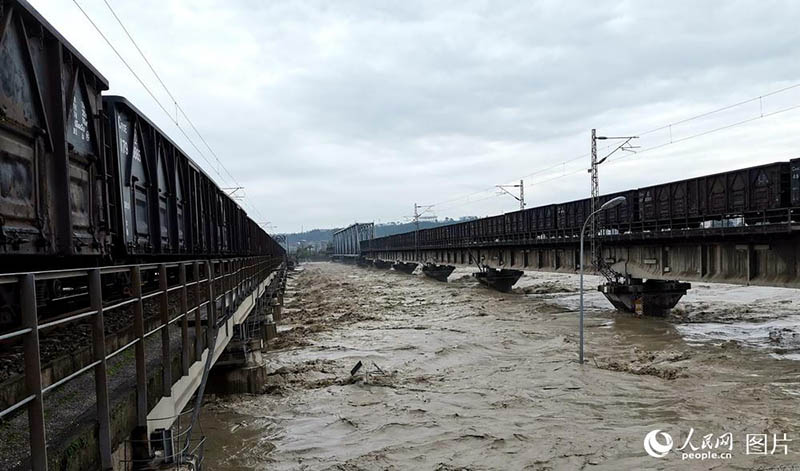 Un train de marchandises roule sur un pont pour éviter son effondrement lors des inondations