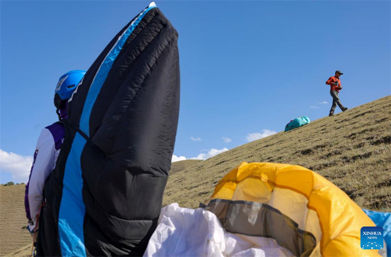Un amateur de parapente cherche à découvrir davantage la beauté du Xinjiang depuis le ciel