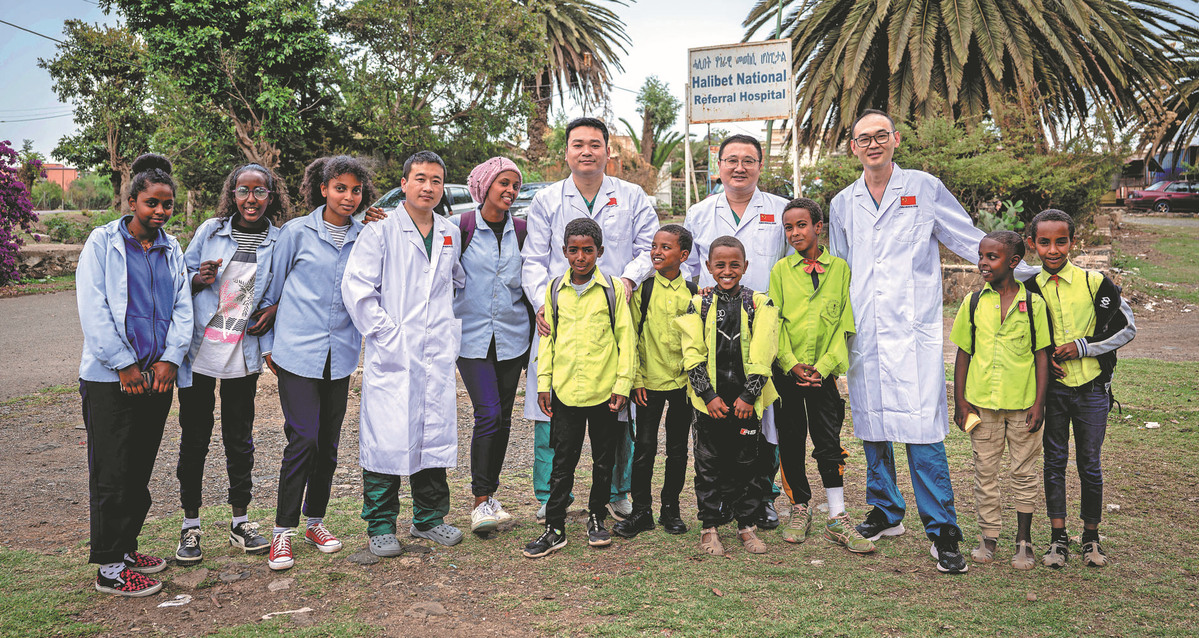 Des membres de l'équipe médicale chinoise posent pour une photo de groupe avec des étudiants locaux à la porte de l'h?pital Halibet, le 9 mai. (Wang Guansen / Xinhua)