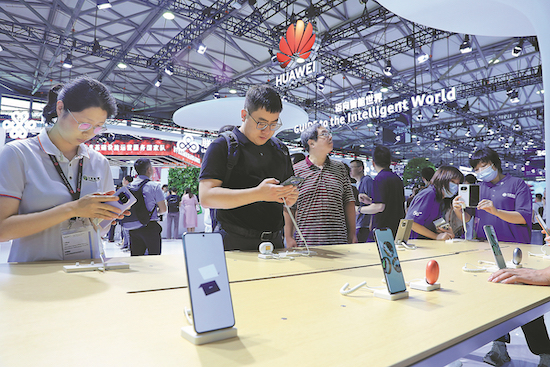 Des visiteurs essaient des téléphones portables Huawei lors d