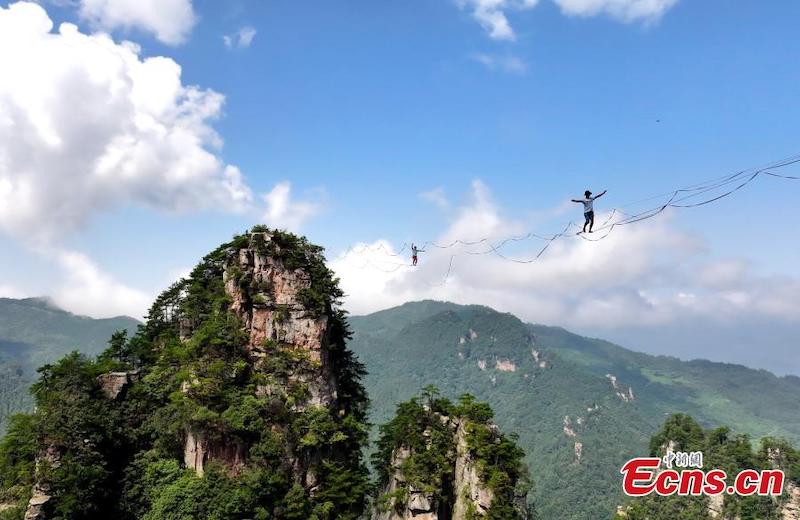 Des funambules marchent sur des cordes raides dans les airs lors d'un concours de slackline dans le Parc forestier national de Zhangjiajie, dans la province du Hunan (centre de la Chine), le 22 ao?t 2023. (Wu Yongbing / China News Service)