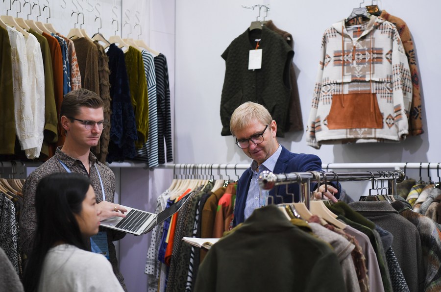Des acheteurs étrangers discutent des affaires sur un stand de vêtements lors de la troisième phase de la 134e Foire de Canton à Guangzhou, capitale de la province du Guangdong (sud de la Chine), le 31 octobre 2023. (Deng Hua / Xinhua)