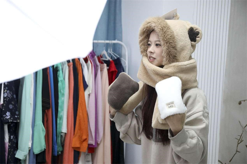 Une animatrice vend des chapeaux et des écharpes produits localement via une diffusion en direct à Hangzhou, capitale de la province du Zhejiang (est de la Chine). (Xu Junyong / Pic.people.com.cn)