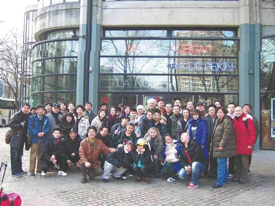 Patrick Sommier pose avec des membres d'une troupe invitée du Collège professionnel d'opéra et d'arts de Beijing devant un théatre à Bobigny, près de Paris, en 2010. (Photo / Xinhua)