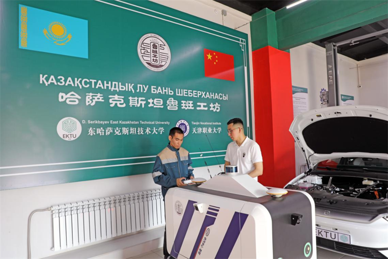 Dans la zone de formation aux technologies de maintenance automobile de l'atelier Luban, au Kazakhstan, deux techniciens conduisent et déboguent un véhicule robot intelligent fourni par la partie chinoise. L'atelier Luban au Kazakhstan est situé à ?skemen, la capitale de la province du Kazakhstan-Oriental. Le projet a été construit conjointement par l'Université professionnelle de Tianjin et l'Université technique du Kazakhstan Oriental et a commencé ses essais le 9 décembre 2023. (Zhao Yipu / Le Quotidien du Peuple)