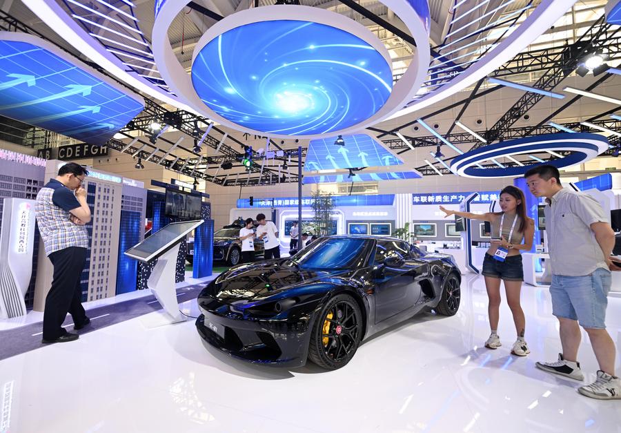 Des visiteurs regardent une voiture de sport à énergie nouvelle présentée lors de l'Exposition mondiale de l'intelligence 2024, à Tianjin, dans le nord de la Chine, le 22 juin 2024. (Photo : Zhao Zishuo)