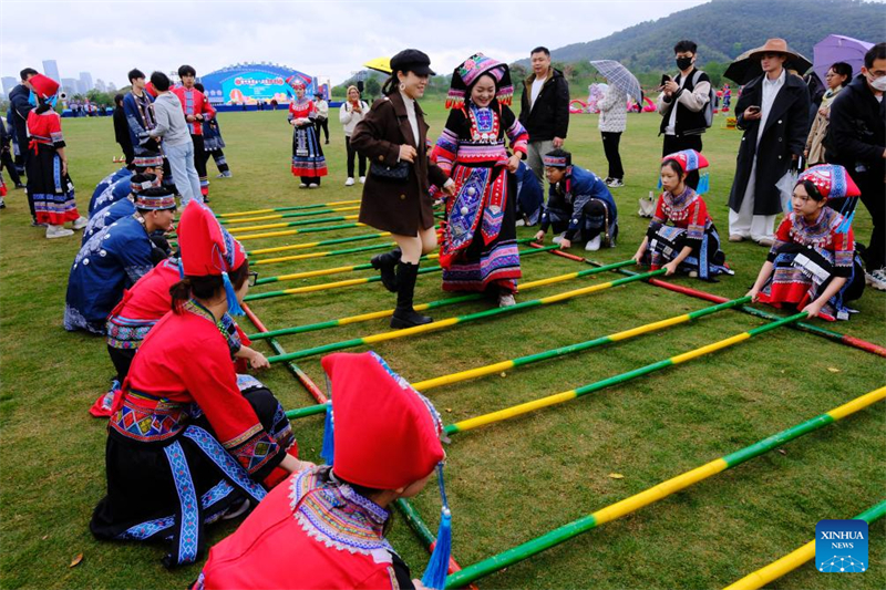 Une touriste s'essaie à la danse sur tiges de bambou dans le site touristique du mont Qingxiu à Nanning, capitale de la région autonome Zhuang du Guangxi (sud de la Chine), le 29 mars 2025. (Photo / Xinhua)