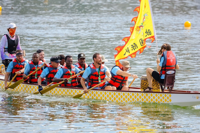 Hainan : des jeunes étrangers participent à une course de bateaux-dragons à Sanya