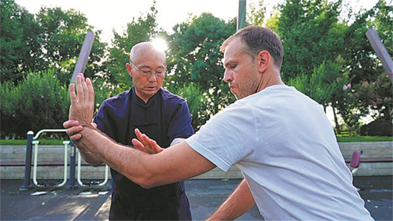 Zhang Daojin, héritier de la boxe de la mante religieuse des Six Harmonies de la province du Shandong (est de la Chine), enseigne à l'un de ses élèves étrangers en 2024. (Photo / Xinhua)
