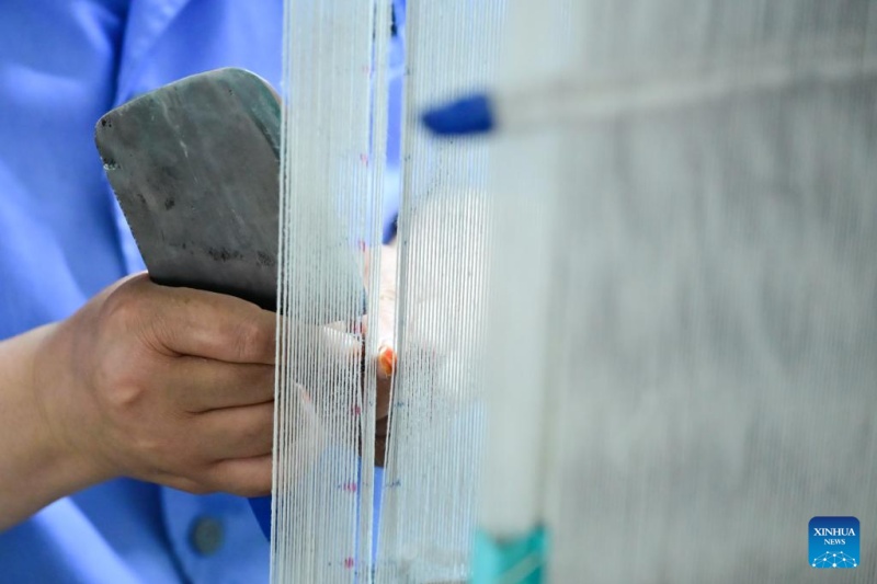 Un employé trie des fils dans un atelier du groupe Shengyuan Carpet à Xining, capitale de la province du Qinghai (nord-ouest de la Chine), le 21 juillet 2025. (Qi Zhiyue/Xinhua)