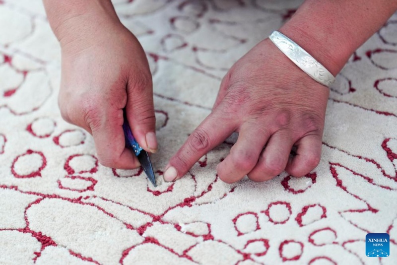 Une employée travaille sur un tapis tibétain dans un atelier du groupe Shengyuan Carpet, à Xining, capitale de la province du Qinghai (nord-ouest de la Chine), le 21 juillet 2025. (Qi Zhiyue/Xinhua)