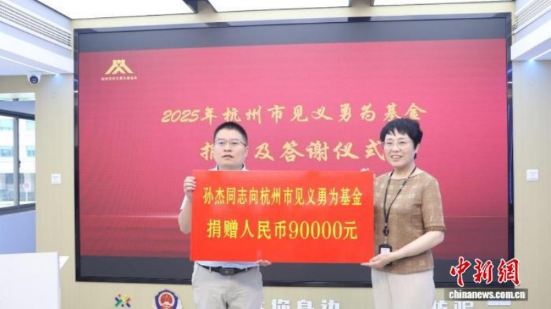 Sun Jie fait don de son prix de 90 000 yuans (environ 12 537 dollars) à la Fondation pour la justice et le courage de Hangzhou, le 1er ao?t. (Photo / China News Service)