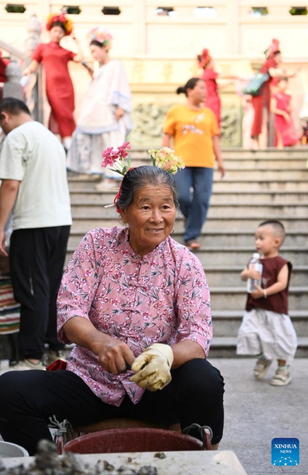 Fujian?: les couvre-chefs fleuris traditionnels stimulent l'essor touristique du village de Xunpu