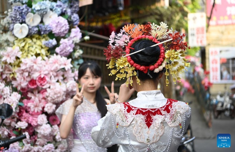Fujian?: les couvre-chefs fleuris traditionnels stimulent l'essor touristique du village de Xunpu