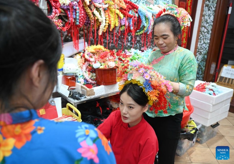 Fujian?: les couvre-chefs fleuris traditionnels stimulent l'essor touristique du village de Xunpu