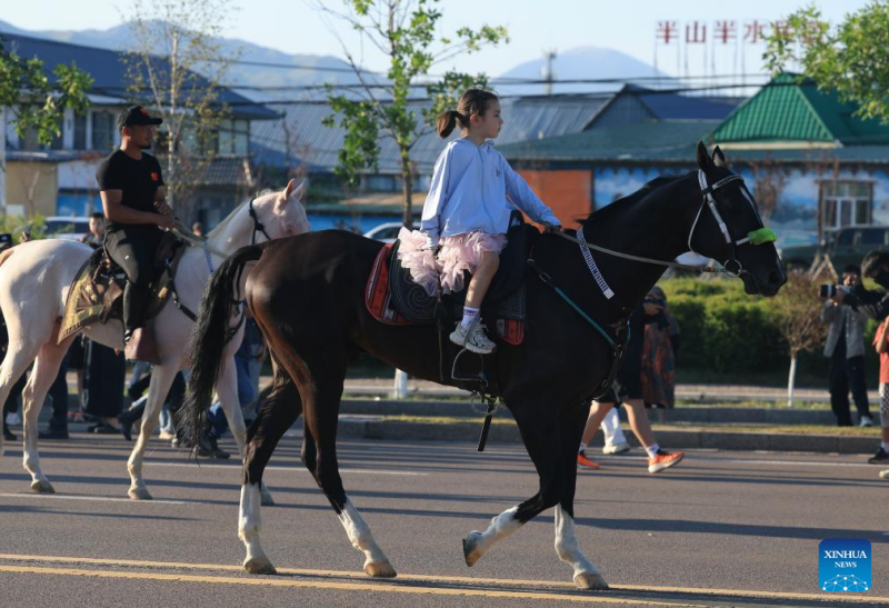 Shakira, la fille de Shirzat Nulum, assiste à un défilé équestre et à une performance équestre lors d'un festival annuel de tourisme culturel équestre dans le district de Zhaosu, dans la région autonome ou?goure du Xinjiang (nord-ouest de la Chine),  le 18 juillet 2025. (Photo / Xinhua)