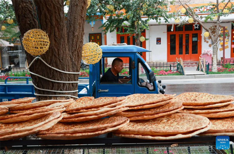 Photo prise le 21 juillet 2025 montrant un stand vendant du naan le long d'une rue à Kuqa, dans la région autonome ou?goure du Xinjiang (nord-ouest de la Chine). (Photo/Xinhua)
