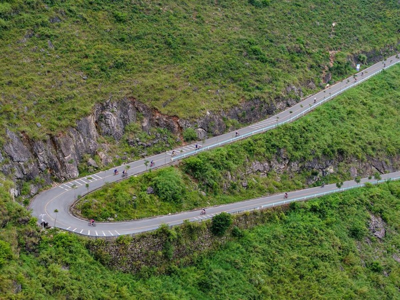 Des concurrents s'affrontent dans l'épreuve de cyclisme lors du premier Challenge international de triathlon du plus haut pont du monde, dans la province chinoise du Guizhou (sud-ouest), le 21 septembre 2025. (Photo : Long Jianrui)