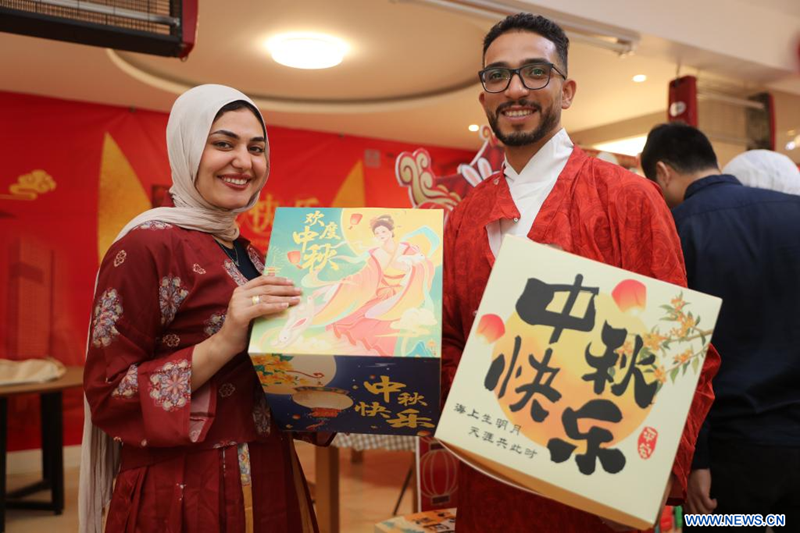 Des employés posent pour des photos lors d'une célébration de la fête traditionnelle chinoise de la mi-automne dans le quartier central des affaires (CBD) de la nouvelle capitale administrative, à l'est du Caire, en Egypte, le 28 septembre 2025. (Xinhua/Sui Xiankai)