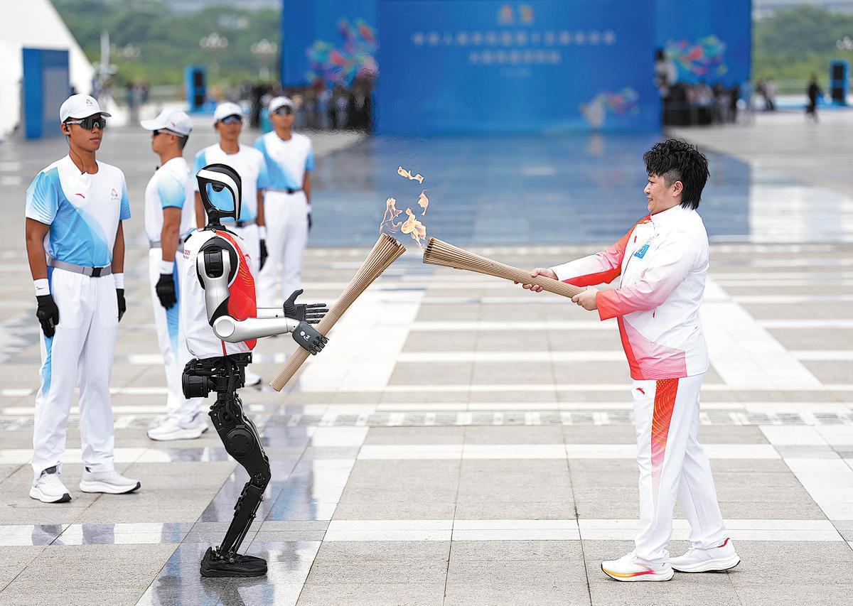 Yu Yang, médaillée d’or olympique de badminton, allume la flamme depuis celle portée par le robot humano?de Kuavo le 3 novembre, lors du relais de la flamme organisé à Shenzhen, dans la province du Guangdong (sud de la Chine), pour les 15es Jeux nationaux. (Jiang Han / Xinhua)