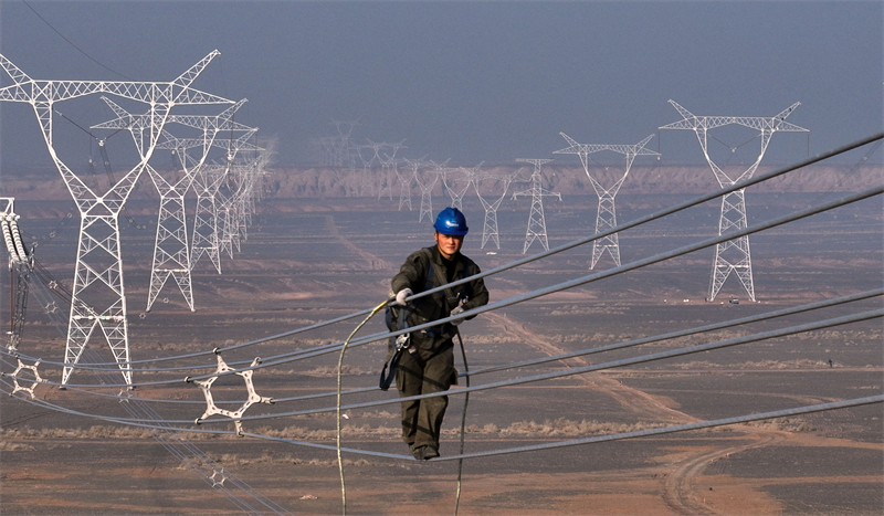 Xinjiang : des techniciens inspectent les lignes électriques en altitude pour éliminer les défauts à Qitai